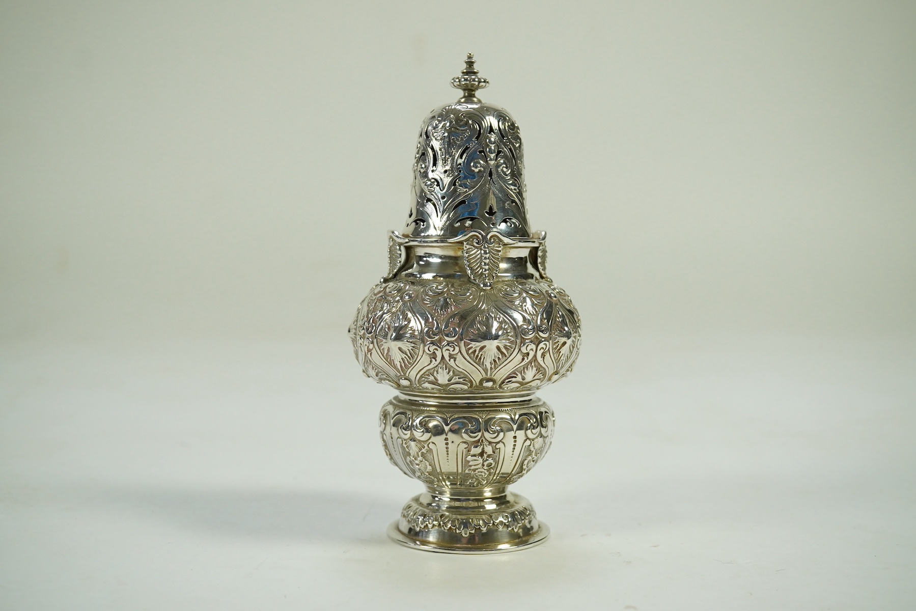 An ornate Edwardian silver sugar castor by Holland, Aldwinckle & Slater